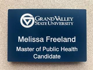 MPH Student Nametag Sample, showing blue plastic tag with white engraving.